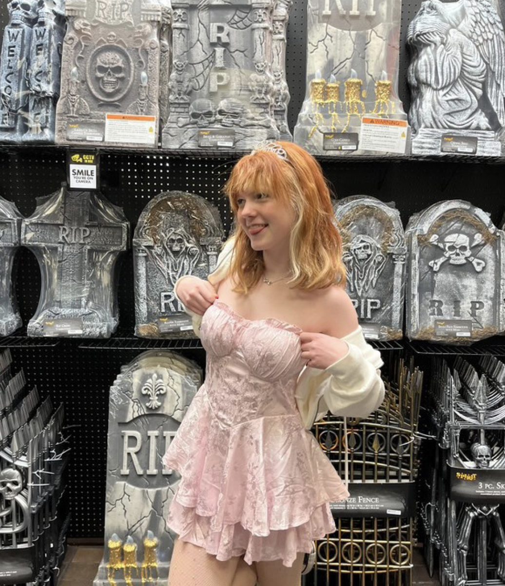 Nichols poses in front of plastic gravestones, dressed in a pink outfit and topped with a tiara. It's that time of year!